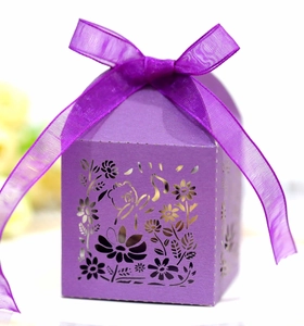Detail of purple hollow-out gift box with fine floral patterns and a ribbon bow