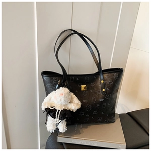 Detail of black pebbled leather tote bag with animal prints and white rabbit doll charm