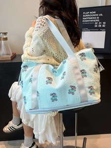 Foldable light blue travel tote bag with cartoon dog print and wide nylon strap