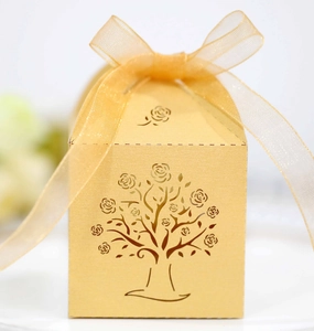 Detailed laser-cut tree of life pattern on champagne gold hollow gift box with ribbon