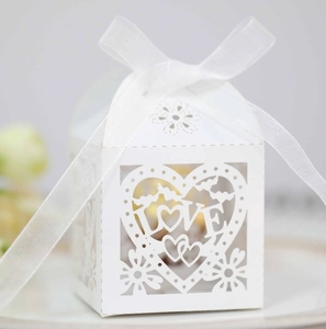 Détail de motif cœur et LOVE découpé au laser sur boîte cadeau de mariage blanche avec ruban