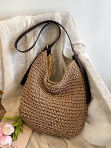 Large capacity khaki woven straw tote bag with brown leather shoulder straps on linen cloth