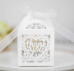 Detailed laser-cut white favor box with Thank You heart design and a white silk ribbon