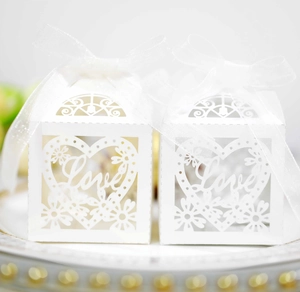 Detailed laser-cut white wedding favor box with Love heart motif and ribbon bow