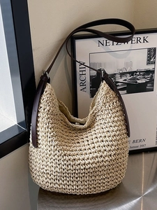 Large beige woven straw shoulder bag with dark brown leather straps for beach or daily use
