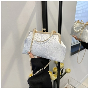 Detail of silver floral jacquard clutch with gold kiss-lock frame and chain strap