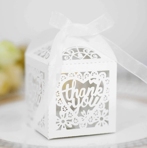 Close-up of laser-cut lace heart and thank you text on white wedding favor box