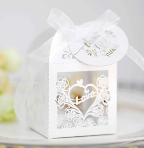 Macro shot of white laser-cut wedding favor box with love text and thank you tag