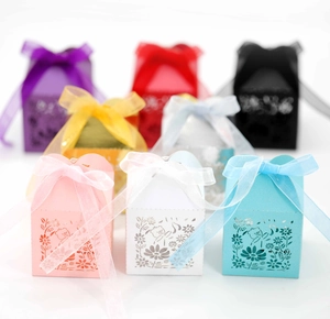 Detail of laser-cut party candy boxes with bear patterns and colorful organza bows