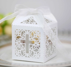 Détail macro d'une boîte cadeau blanche découpée au laser avec croix et ruban de soie