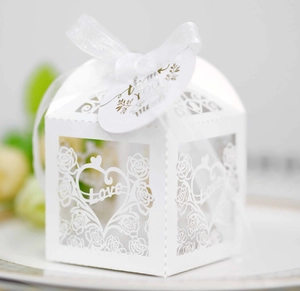 Detailed laser-cut rose and heart patterns on white wedding candy box with ribbon