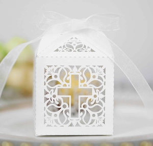 Détail de boîte cadeau blanche découpée au laser avec motif croix et ruban en organza