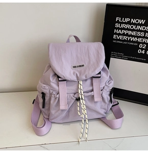 Detail of lavender nylon backpack with buckle closure, striped ropes and brand label