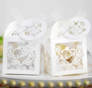 Detail of laser-cut heart and rose design candy box with white ribbon and thank you tag