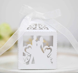 Detailed laser cut white wedding candy box featuring a bride and groom heart motif