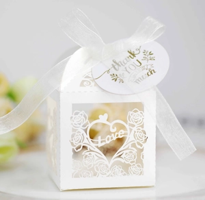 Detail of white laser-cut favor box with Love motif and thank you tag with ribbon