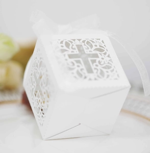 Détail de boîte cadeau ajourée au laser avec motif de croix et ruban en organza blanc