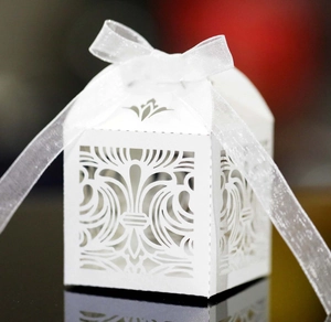Intricate laser-cut patterns on a white gift box with elegant organza ribbon bow