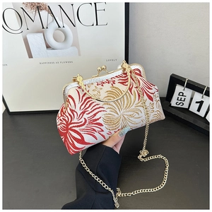 Detailed embroidery of gold and red flowers on an elegant retro shell-shaped evening bag