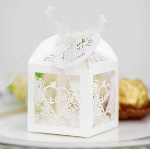 Detail of white laser-cut wedding gift box with ribbon and Thank You tag decor