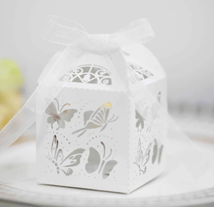 Makro-Detail einer weißen Laser-Cut Schmetterling-Süßigkeitenbox mit Organza-Schleife