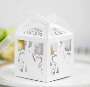 Detail of laser-cut heart and silhouette on white wedding candy box with ribbon
