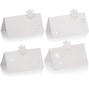 Macro detail of laser-cut snowflake table cards with white glitter for wedding and Christmas