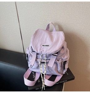 Detail of light purple waterproof nylon backpack with drawstring closure and leather logo