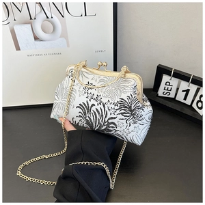 Detail of vintage shell bag with floral patterns and golden chain strap