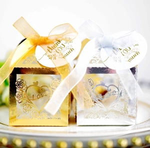 Detailed close-up of gold and silver hollow rose candy boxes with thank you tags