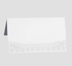 Close-up of white laser cut lace name card with intricate hollow pattern for weddings