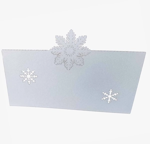 Close-up of laser-cut white snowflake place card for Christmas wedding table settings