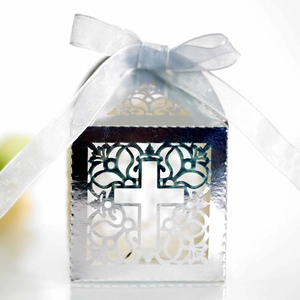 Détail de la boîte à bonbons argentée découpée au laser avec croix, fleurs et ruban blanc