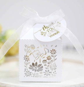Detail of white hollowed-out bear candy box with sunflower laser cut and organza ribbon