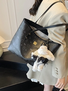 Fashionable black leather tote bag with bear print and cute plush bunny charm on shoulder