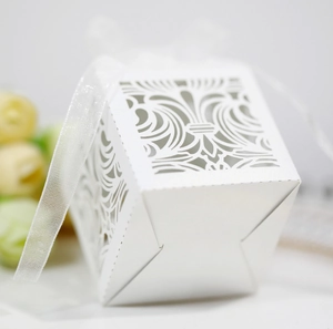 Détail macro d'une boîte à bonbons blanche découpée au laser avec ruban et fleurs