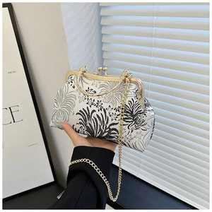 Detail of vintage brocade floral shell bag with golden metal frame and top handle