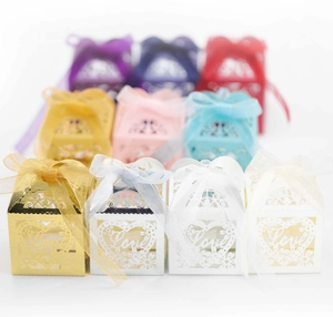 Macro view of laser-cut heart favor boxes with Love lettering and ribbon bows