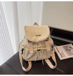 Detail of cream nylon backpack with drawstring closure and buckle strap for students