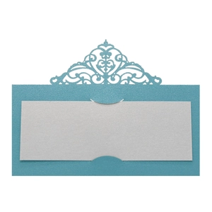 Detail of laser-cut pearl paper place card with elegant scrollwork for wedding seating