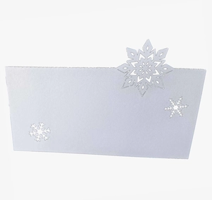 Detailed laser-cut white snowflake hollow design on a Christmas wedding table card