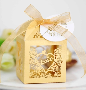 Detail of golden laser-cut wedding favor box with Love motif and thank you tag