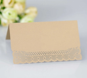 Elegant laser-cut lace place card in kraft brown standing for wedding table decor
