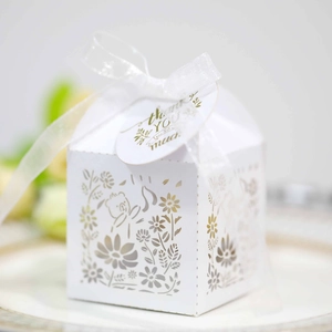 Macro view of white hollow bear favor box with ribbon and thank you tag detail