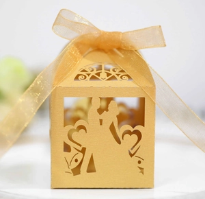 Golden laser-cut wedding favor box with romantic heart and couple silhouette design