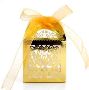 Detail of laser-cut gold wedding favor box with thank you heart and yellow ribbon