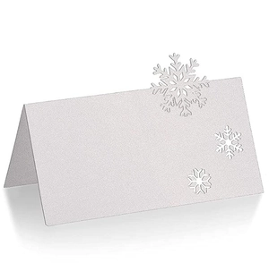 Detailed view of white glitter place card with laser-cut snowflake for winter weddings