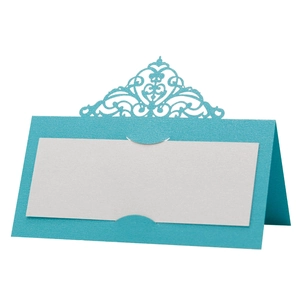 Detail of sky blue laser-cut place card with intricate floral patterns and white insert