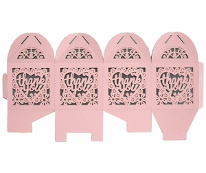 Flat lay of pink heart laser-cut candy boxes with thank you cutout for wedding favors