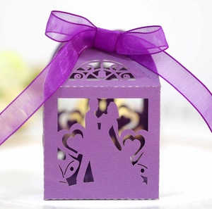 Detail of purple laser-cut wedding favor box featuring romantic couple silhouette and bow